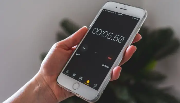 A woman setting an alarm on her iPhone