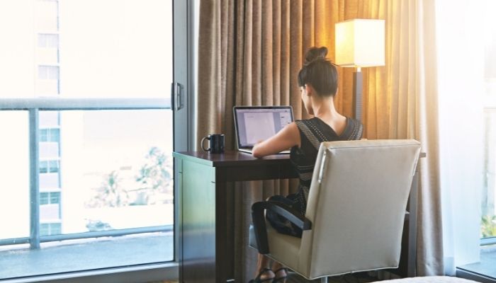 A woman using a VPN while connecting to hotel WiFi on a laptop
