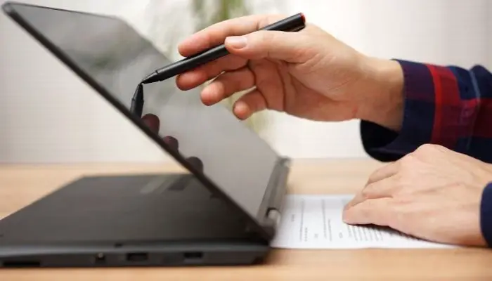 A black 2-in-1 laptop being used with a stylus
