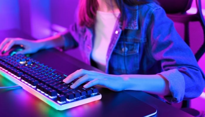 A woman gaming on a gaming keyboard