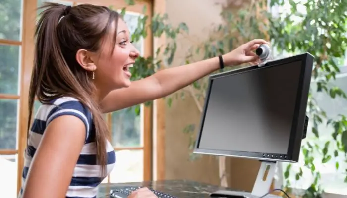A woman setting up a webcam