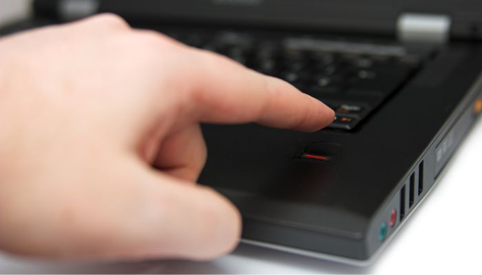 A man using a fingerprint scanner on a laptop