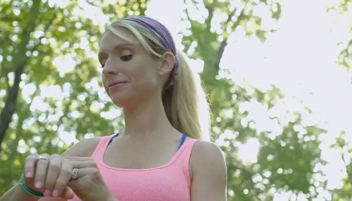 A woman exercising outside with a Fitbit