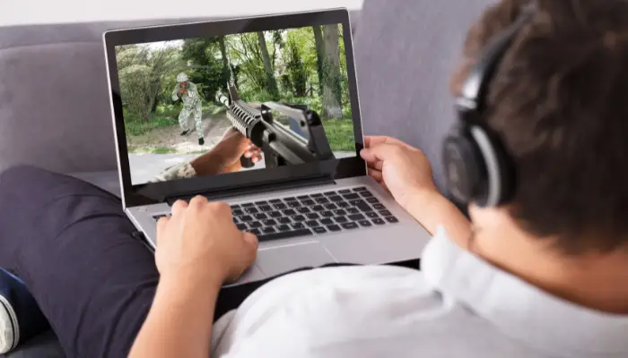 A man using a gaming laptop on his lap